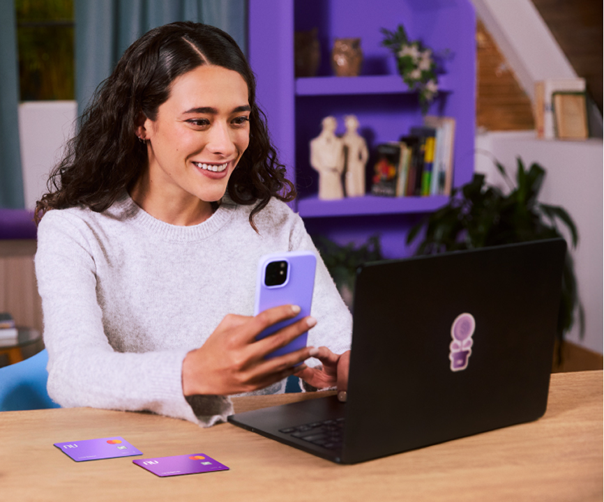 Fotografía de la tarjeta de crédito Nu sostenida por la mano de una persona Fotografía de la tarjeta de crédito Nu sostenida por la mano de una persona